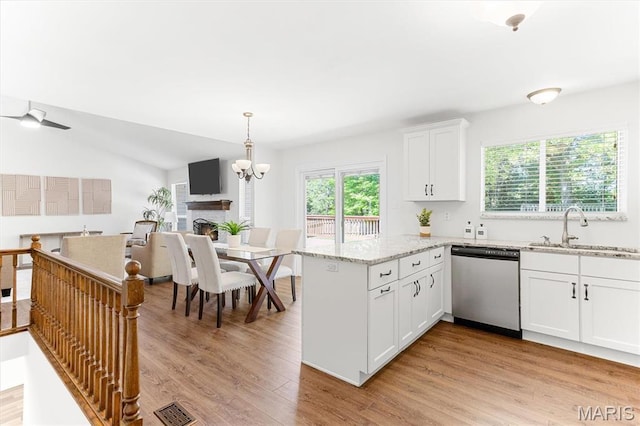 kitchen with dishwasher, a sink, white cabinetry, a peninsula, and light wood finished floors