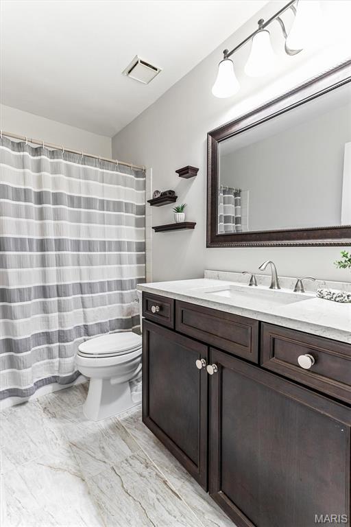 full bathroom with vanity, toilet, and marble finish flooring