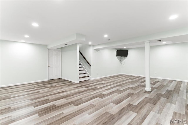 finished below grade area featuring recessed lighting, stairway, light wood-style flooring, and baseboards