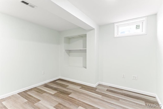 spare room featuring wood finished floors and baseboards