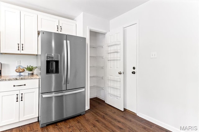 kitchen featuring stainless steel fridge with ice dispenser, light stone countertops, white cabinetry, and dark wood-style floors