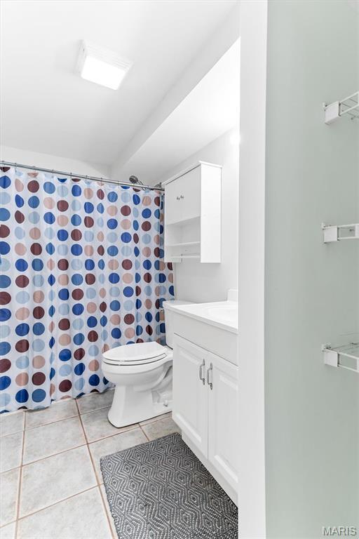 full bathroom featuring tile patterned flooring, toilet, vanity, and a shower with shower curtain