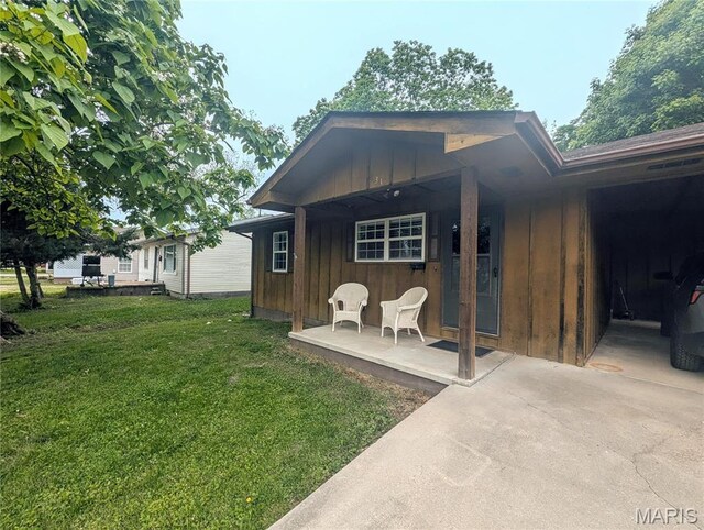 631 W Victor St, Poplar Bluff, MO 63901 - rear view of property with board and batten siding, a lawn, and covered porch