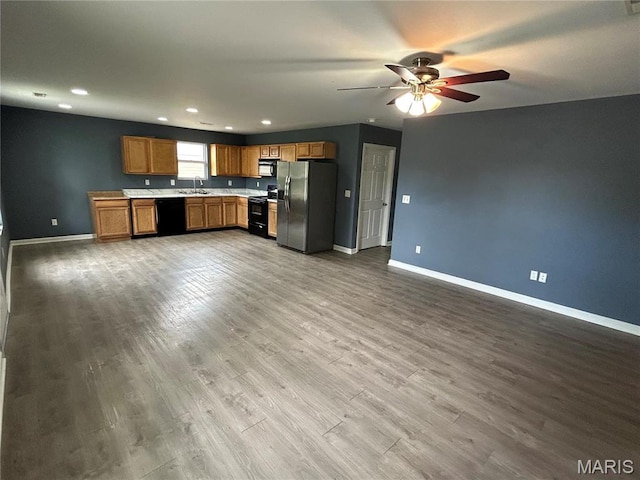 kitchen featuring black appliances, a sink, baseboards, light countertops, and recessed lighting