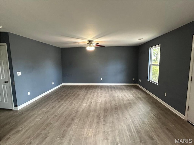 unfurnished room featuring ceiling fan, wood finished floors, and baseboards