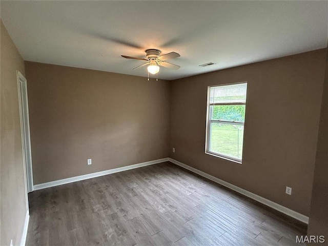 spare room with ceiling fan, wood finished floors, and baseboards