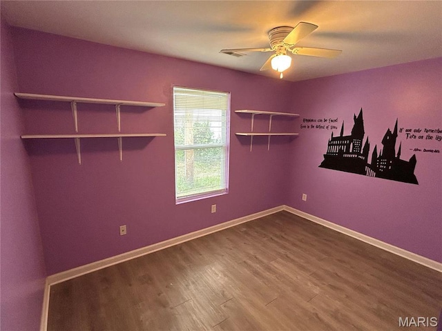 empty room featuring wood finished floors, a ceiling fan, and baseboards
