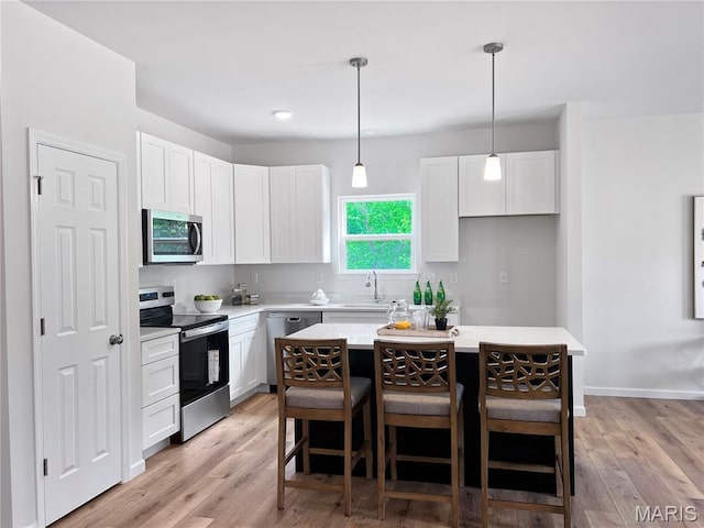 3304 Nat View Ct, Washington, MO 63090 - kitchen featuring stainless steel appliances, a breakfast bar, a sink, and white cabinetry
