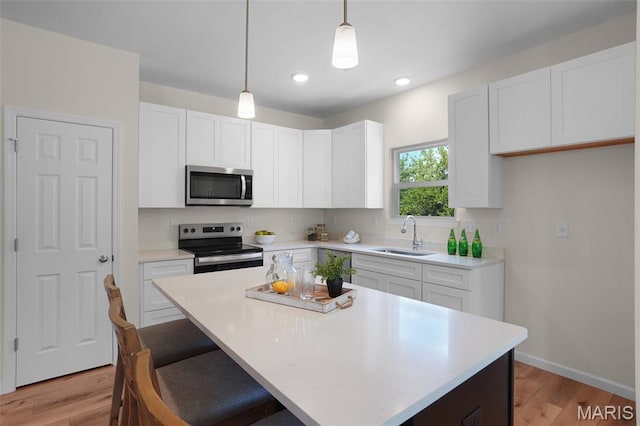 3304 Nat View Ct, Washington, MO 63090 - kitchen featuring stainless steel appliances, light wood-style flooring, white cabinetry, light countertops, and recessed lighting