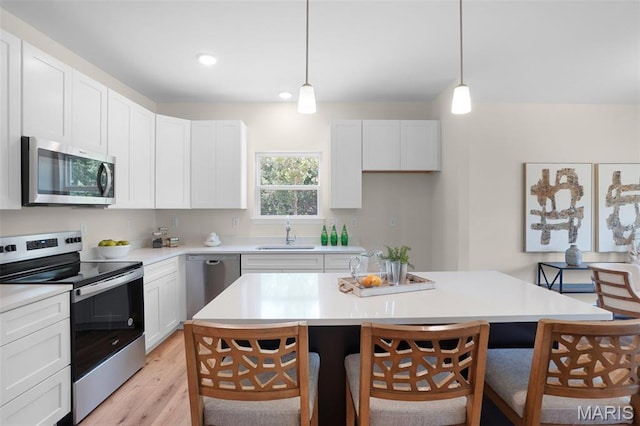 3304 Nat View Ct, Washington, MO 63090 - kitchen with stainless steel appliances, a kitchen breakfast bar, light wood-style floors, pendant lighting, and recessed lighting