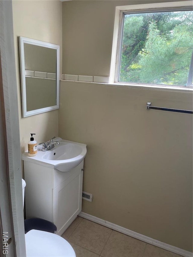 219 2nd St, Winfield, MO 63389 - bathroom featuring vanity, toilet, tile patterned flooring, and baseboards