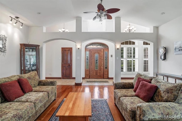 3033 Oakvale Rd, De Soto, MO 63020 - living room with vaulted ceiling, wood finished floors, ceiling fan, a chandelier, and arched walkways
