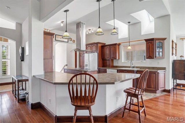 3033 Oakvale Rd, De Soto, MO 63020 - kitchen with island exhaust hood, white appliances, a breakfast bar, wood finished floors, and a sink