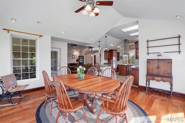 3033 Oakvale Rd, De Soto, MO 63020 - dining room featuring lofted ceiling, light wood-style flooring, a ceiling fan, a skylight, and baseboards