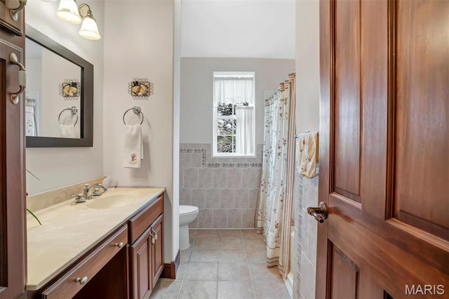 3033 Oakvale Rd, De Soto, MO 63020 - bathroom featuring tile walls, toilet, tile patterned floors, vanity, and wainscoting