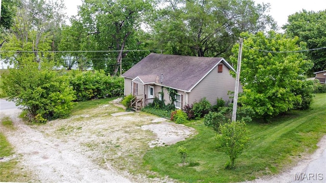 view of subject property with a tree filled landscape