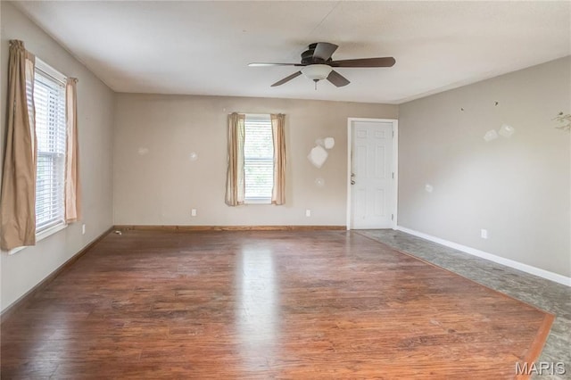 empty room featuring ceiling fan, wood finished floors, and baseboards