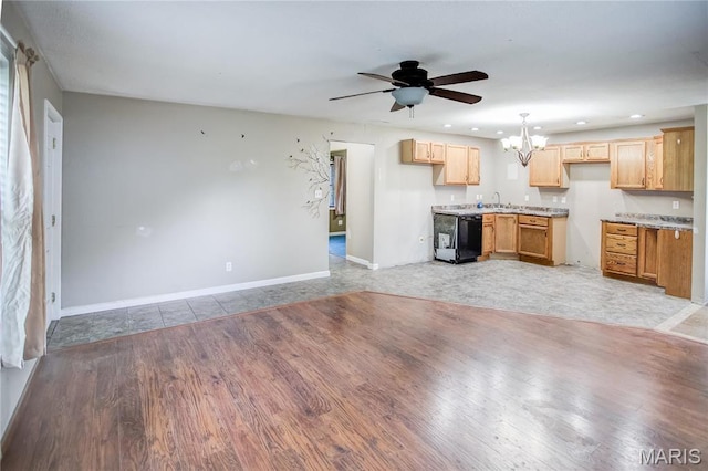 unfurnished living room featuring a chandelier, a ceiling fan, a sink, baseboards, and light wood finished floors