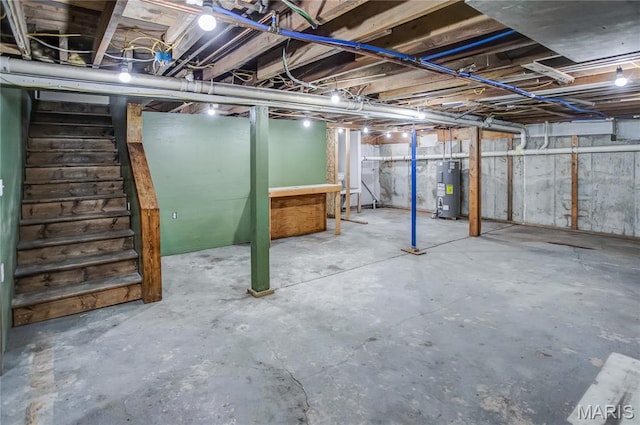 unfinished below grade area with electric water heater and stairway