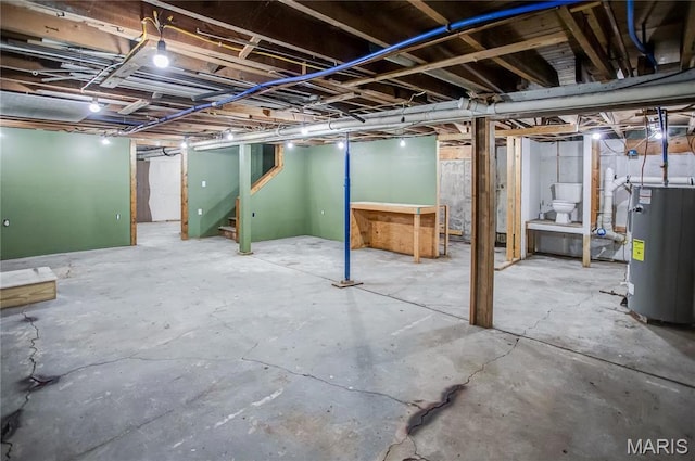 unfinished basement with water heater and stairway