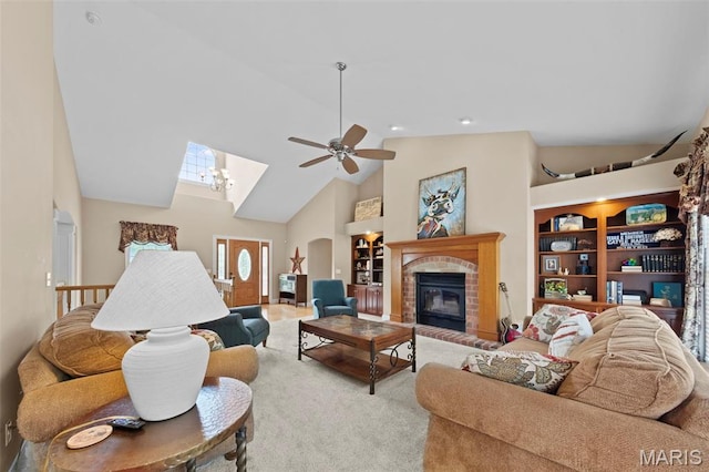 carpeted living room with high vaulted ceiling, a fireplace, a ceiling fan, and built in shelves