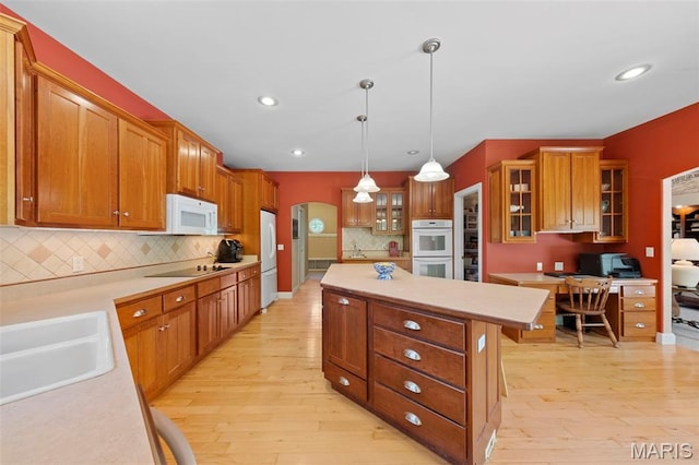 kitchen with white appliances, a sink, light wood-type flooring, light countertops, and recessed lighting