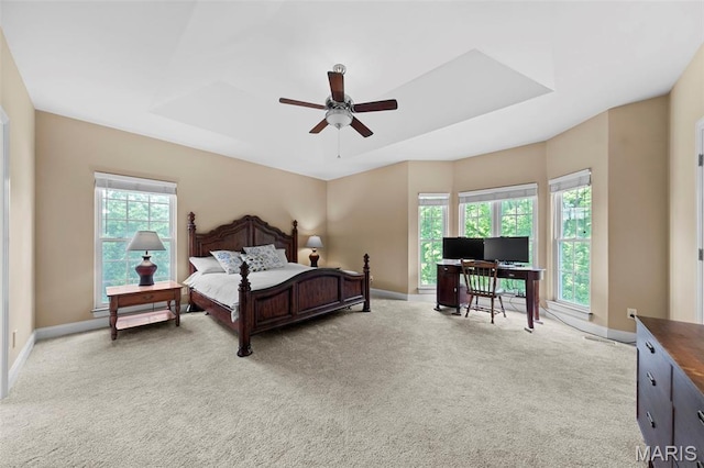 bedroom featuring baseboards, light colored carpet, a desk, and a ceiling fan