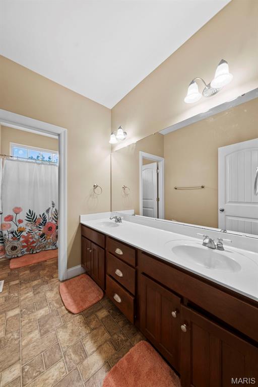 bathroom with double vanity and stone finish floors