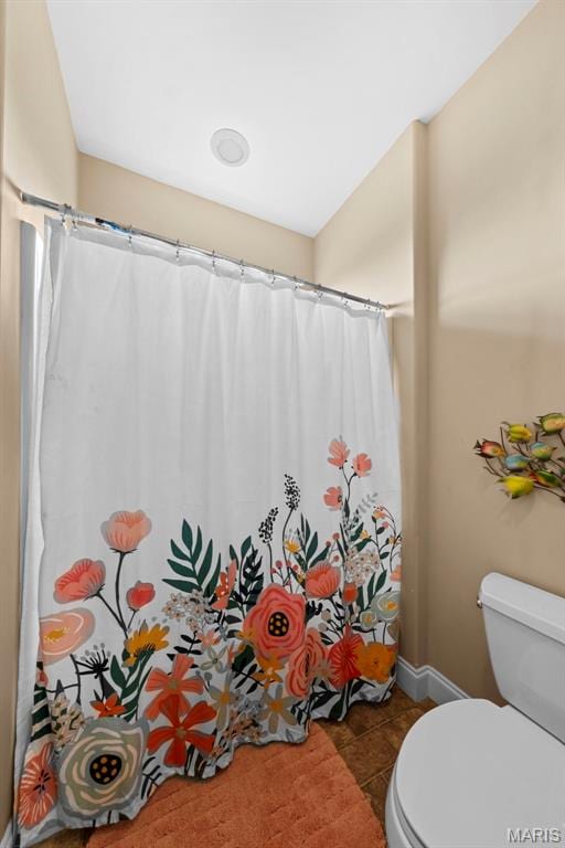 full bathroom featuring toilet, tile patterned flooring, baseboards, and a shower with curtain