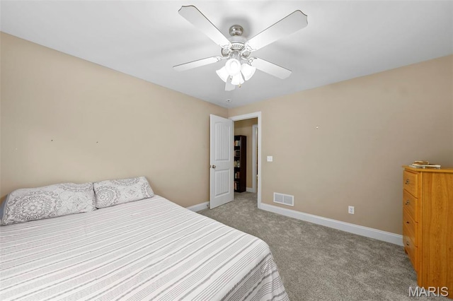 bedroom featuring light colored carpet, baseboards, and a ceiling fan