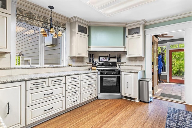 505 Thompson Ln, Arcadia, MO 63621 - kitchen with range with gas cooktop, a chandelier, light wood-style floors, hanging light fixtures, and decorative backsplash