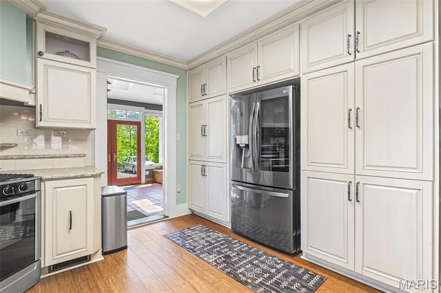 505 Thompson Ln, Arcadia, MO 63621 - kitchen with stainless steel appliances, light wood-style floors, tasteful backsplash, ornamental molding, and light stone countertops