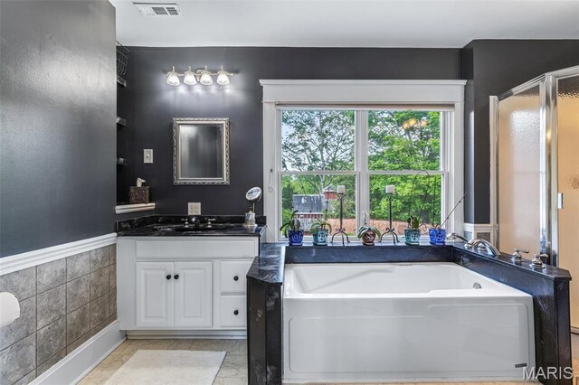 505 Thompson Ln, Arcadia, MO 63621 - bathroom with vanity, a bath, a stall shower, and tile walls