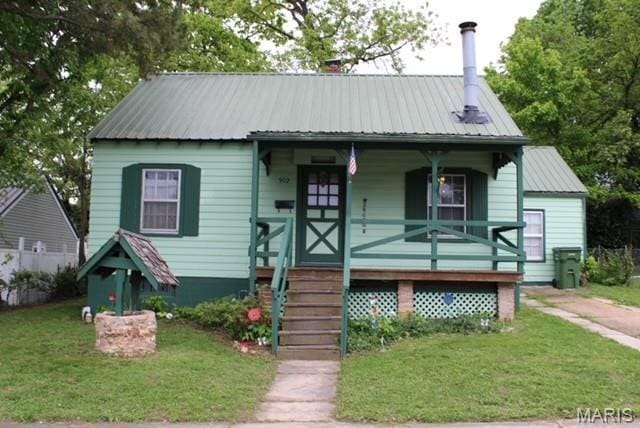 bungalow-style house with a porch, metal roof, and a front lawn