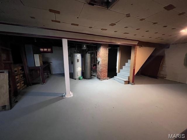 unfinished below grade area with electric water heater, gas water heater, and stairway