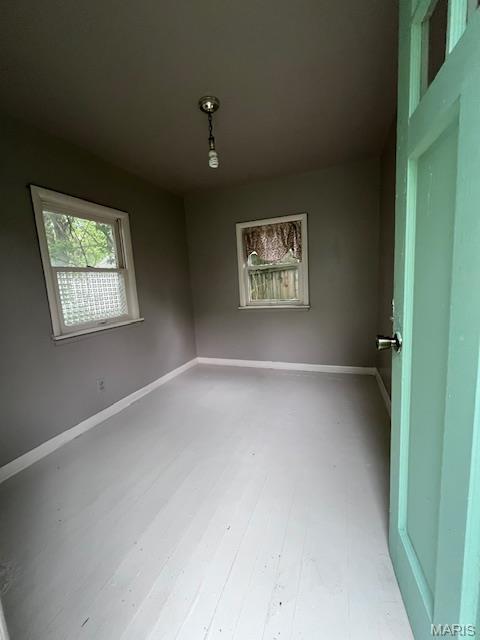 empty room with baseboards and wood finished floors