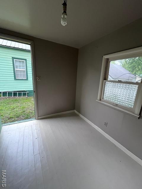 empty room with baseboards and light wood-style flooring