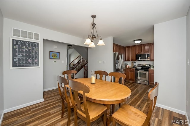 dining room with a chandelier, dark wood-style flooring, baseboards, and stairs