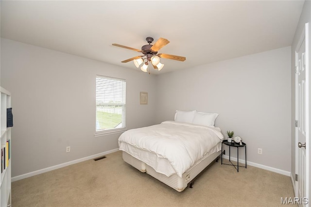 bedroom featuring light carpet, baseboards, and a ceiling fan
