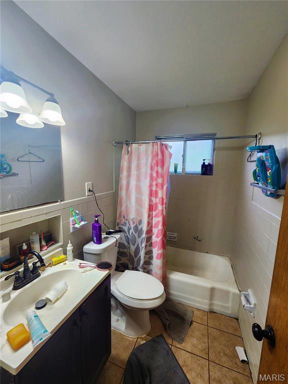 1437 Farmview Ave, Saint Louis, MO 63138 - full bath featuring tile walls, tile patterned flooring, toilet, shower / bath combination with curtain, and vanity