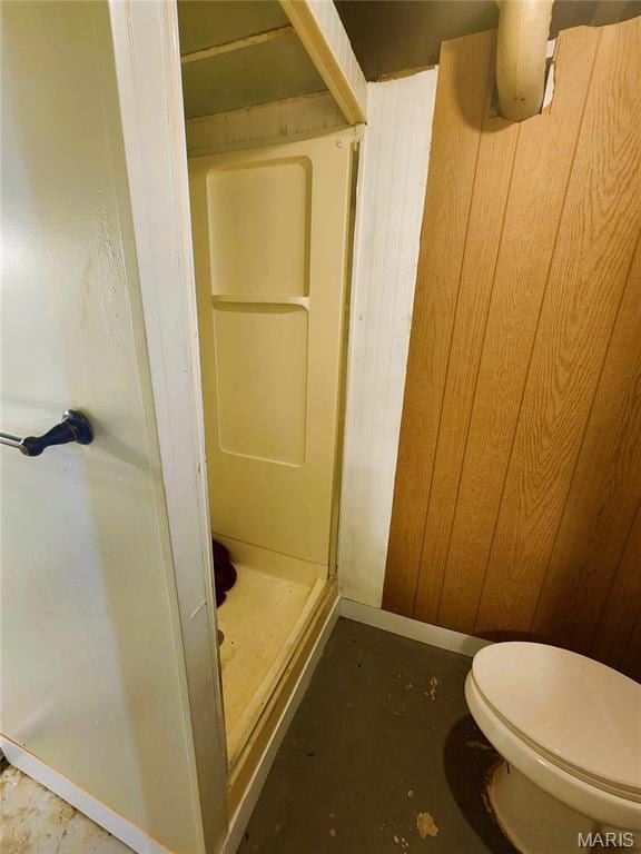 1437 Farmview Ave, Saint Louis, MO 63138 - full bathroom featuring a stall shower, toilet, concrete floors, and wood walls