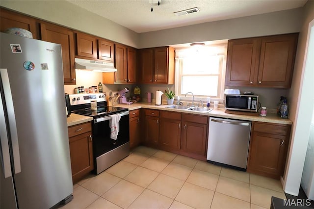 1507 Vine St, Poplar Bluff, MO 63901 - kitchen with stainless steel appliances, a sink, under cabinet range hood, and light countertops