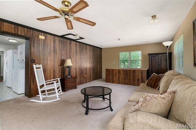 128 Cumberland Ave, Maryland Heights, MO 63043 - living area featuring estacked washer and dryer, wooden walls, light colored carpet, and a ceiling fan