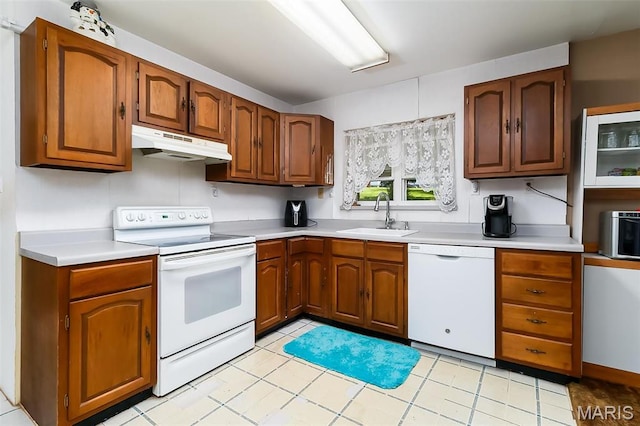 128 Cumberland Ave, Maryland Heights, MO 63043 - kitchen featuring white appliances, under cabinet range hood, a sink, light countertops, and brown cabinetry