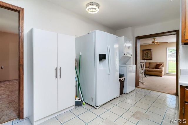 128 Cumberland Ave, Maryland Heights, MO 63043 - kitchen with white fridge with ice dispenser, light colored carpet, stacked washer / dryer, ceiling fan, and light countertops