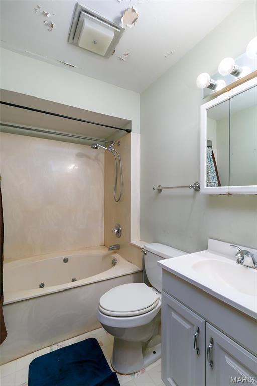 128 Cumberland Ave, Maryland Heights, MO 63043 - bathroom featuring vanity, a combined bath / shower with jetted tub, toilet, and tile patterned floors