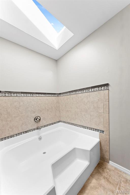 3009 Country Knoll Dr, Saint Charles, MO 63303 - full bath featuring a skylight, a bath, and baseboards