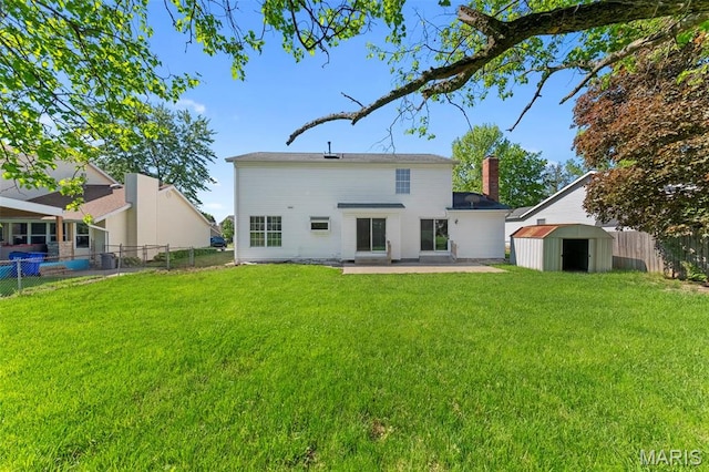 3009 Country Knoll Dr, Saint Charles, MO 63303 - back of house with a shed, a patio area, an outbuilding, and a chimney