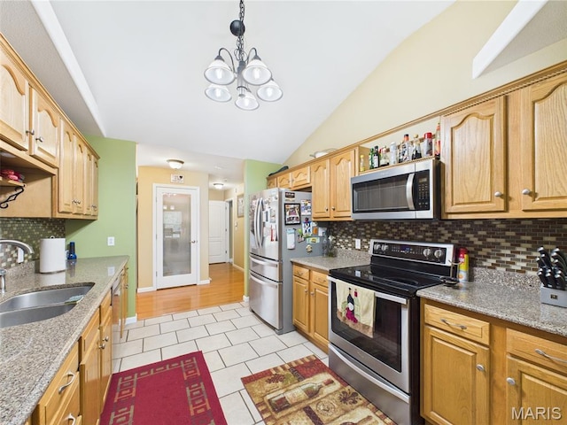 109 Locust Ct, Saint Robert, MO 65584 - kitchen featuring appliances with stainless steel finishes, a sink, lofted ceiling, light tile patterned floors, and tasteful backsplash