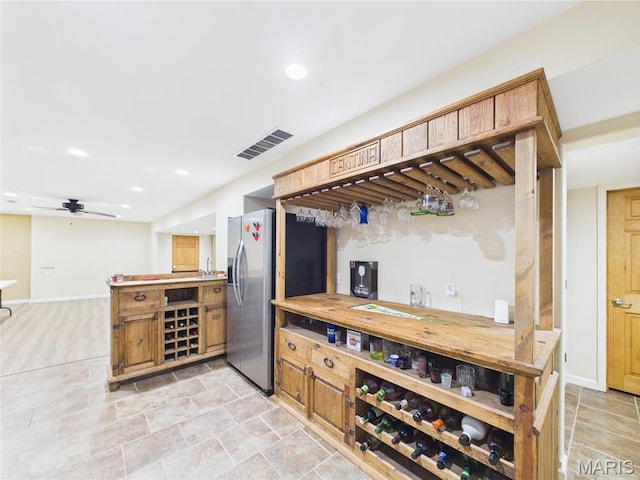 109 Locust Ct, Saint Robert, MO 65584 - bar area featuring baseboards, stainless steel fridge with ice dispenser, a ceiling fan, recessed lighting, and light stone finish floors